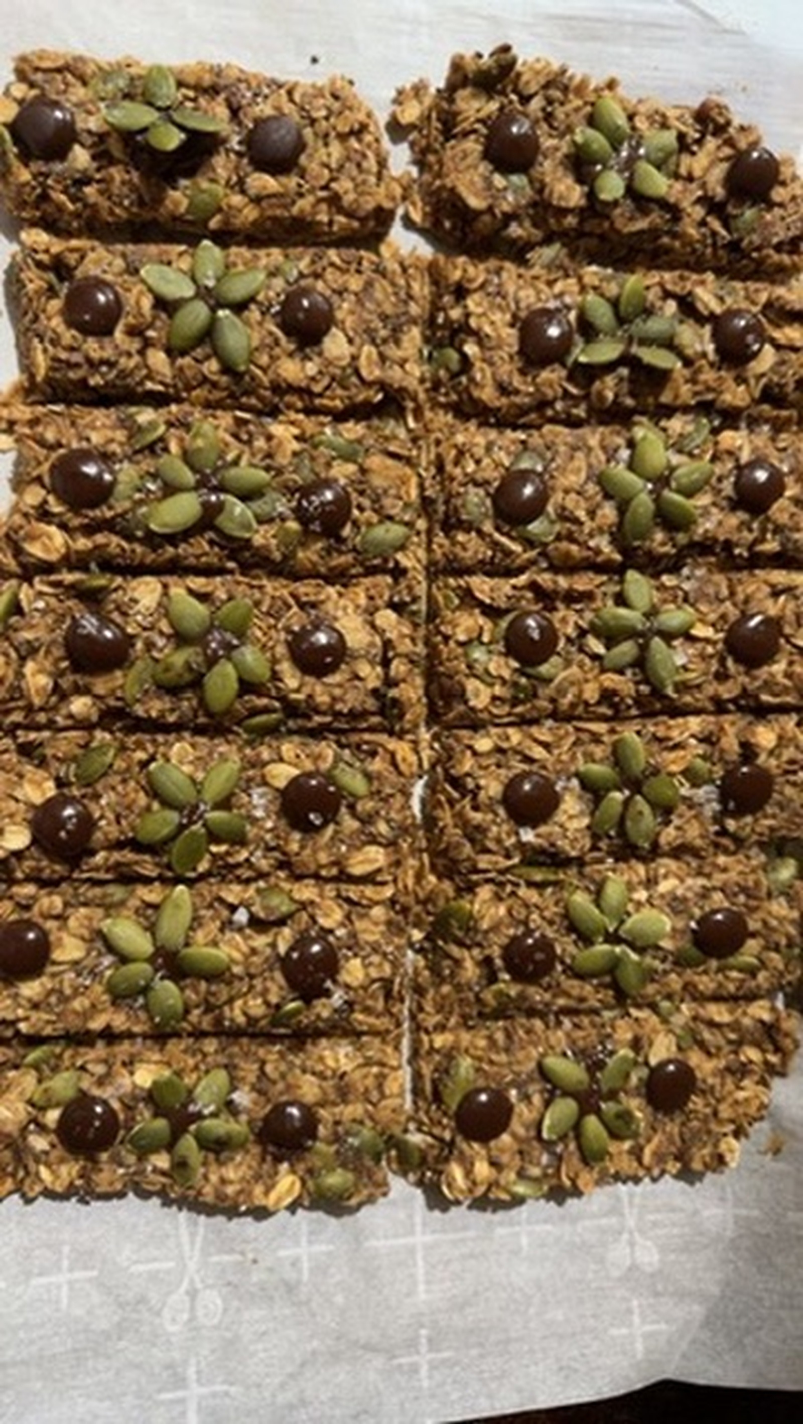 Homemade granola bars topped with pumpkin seeds and chocolate